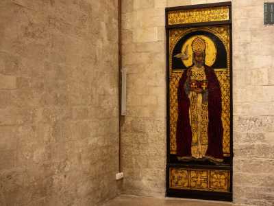 Specularmente al santo di Myra, alla fine del corridoio laterale, un affresco di San Gregorio del 1983 tinge con i suoi accesi toni rosso e oro la spenta muratura di fondo